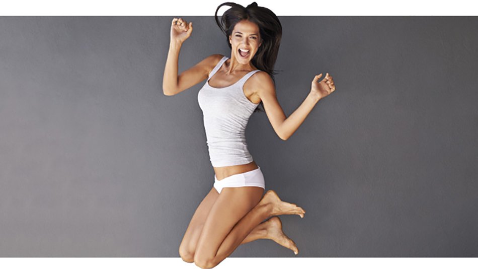 mujer feliz saltando en ropa interior