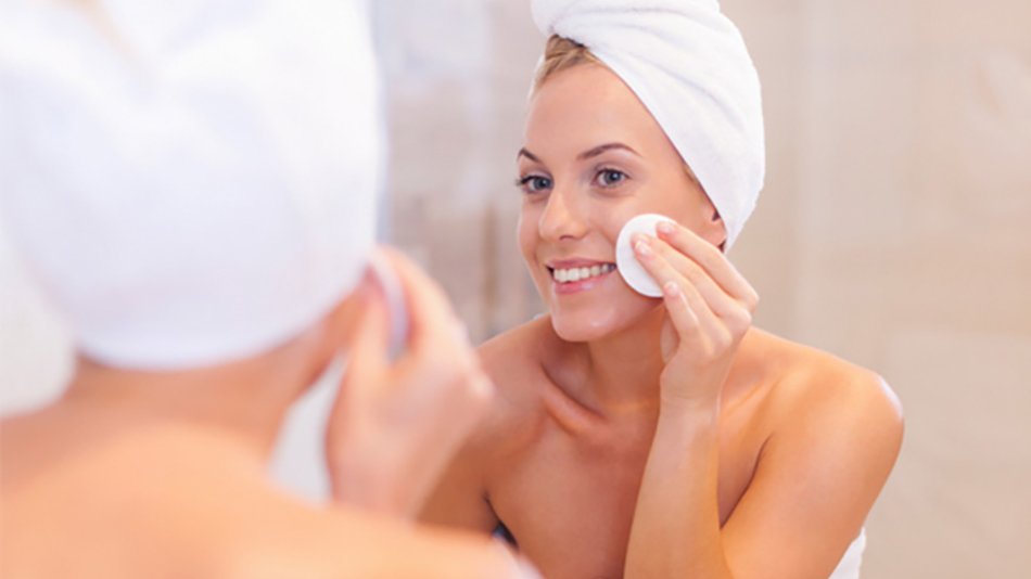 mujer frente al espejo con toalla en el pelo