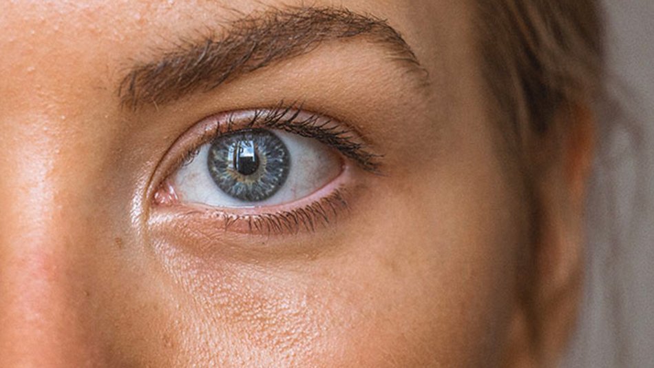 mujer morena mirándose la cara al espejo