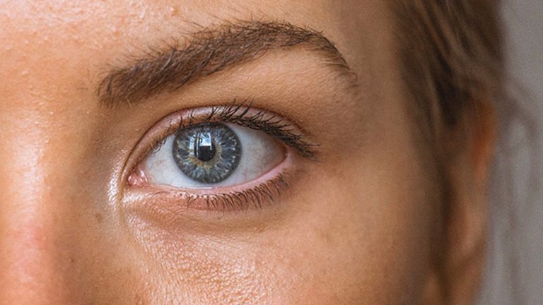 mujer morena mirándose la cara al espejo