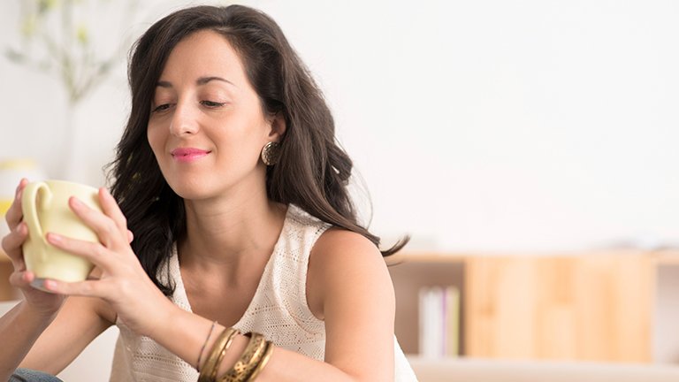 mujer morena mirándose la cara al espejo