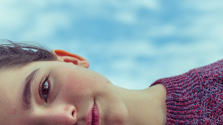 mujer morena mirándose la cara al espejo