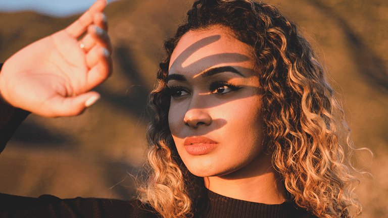 chica tapándose del sol