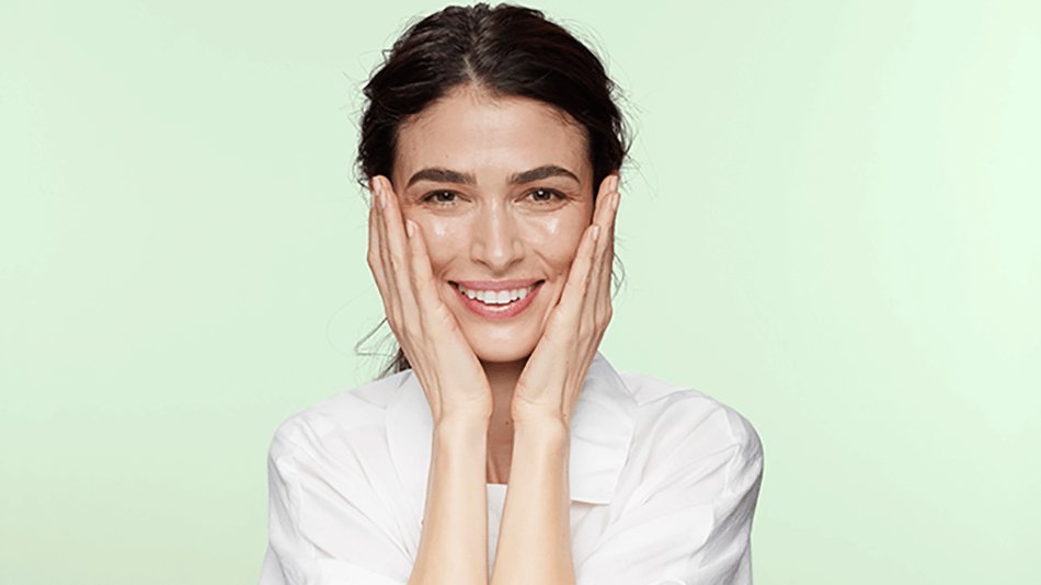 mujer sonriendo tocándose la cara