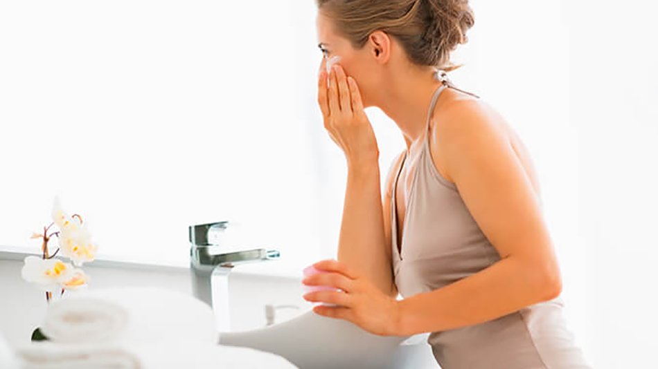 mujer lavándose la cara