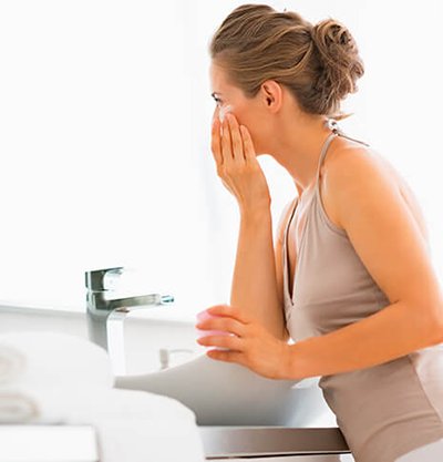 mujer lavándose la cara