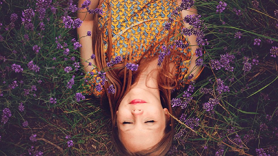 mujer tumbada sobre un campo de lavandas