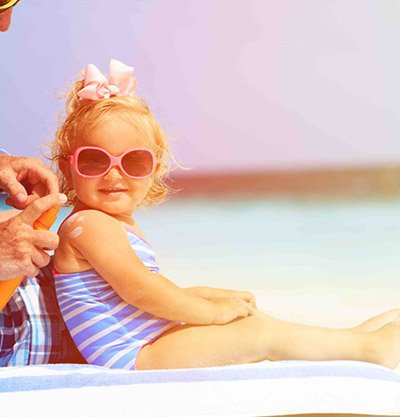 nina pequena en la playa con gafas de sol