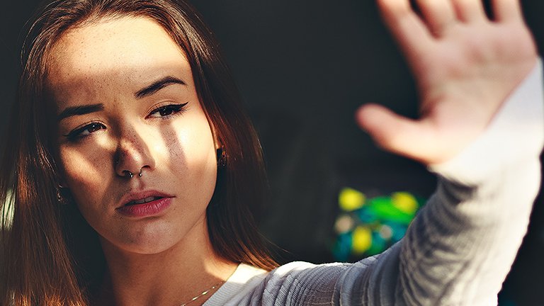 chica tapándose del sol con la mano