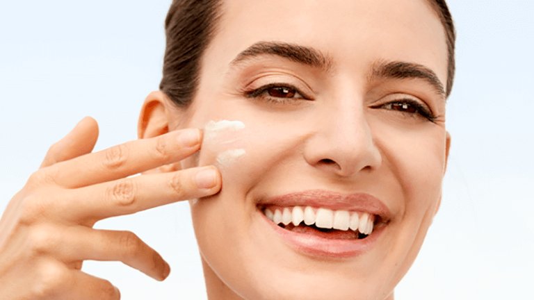 mujer echándose crema en la cara