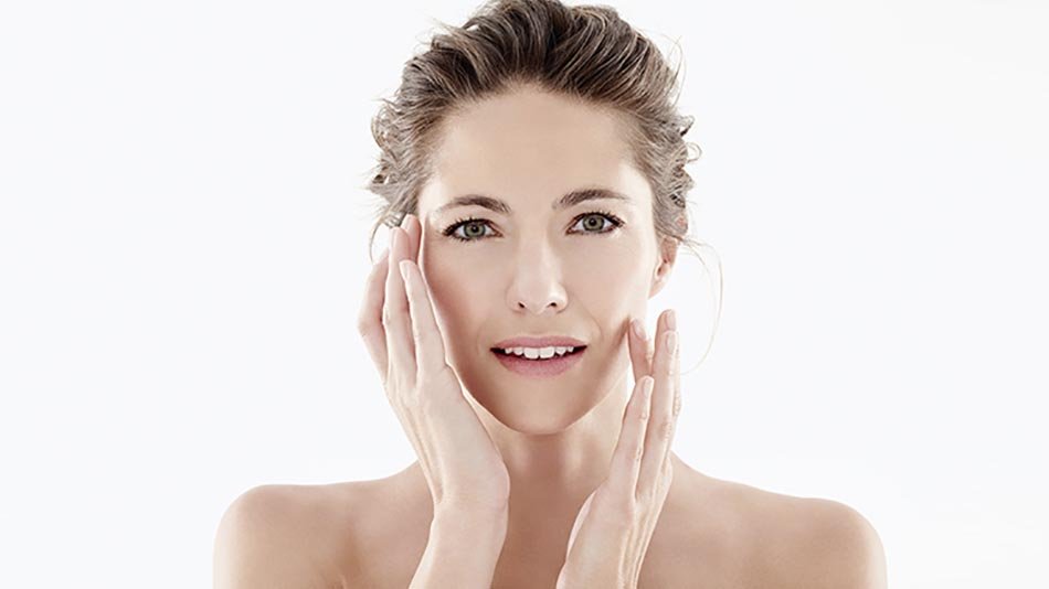 Mujer aplicándose crema en el rostro