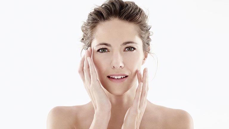 Mujer aplicándose crema en el rostro