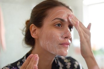 mujer morena mirándose la cara al espejo