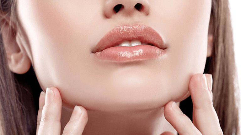 Rostro inferior de chica tocandose la cara con las manos