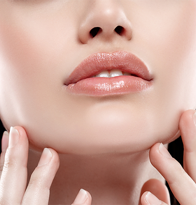 Rostro inferior de chica tocandose la cara con las manos