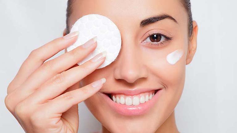 Chica limpiandose el ojo con un disco de algodon